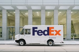 A FedEx delivery truck parked in front of an office building