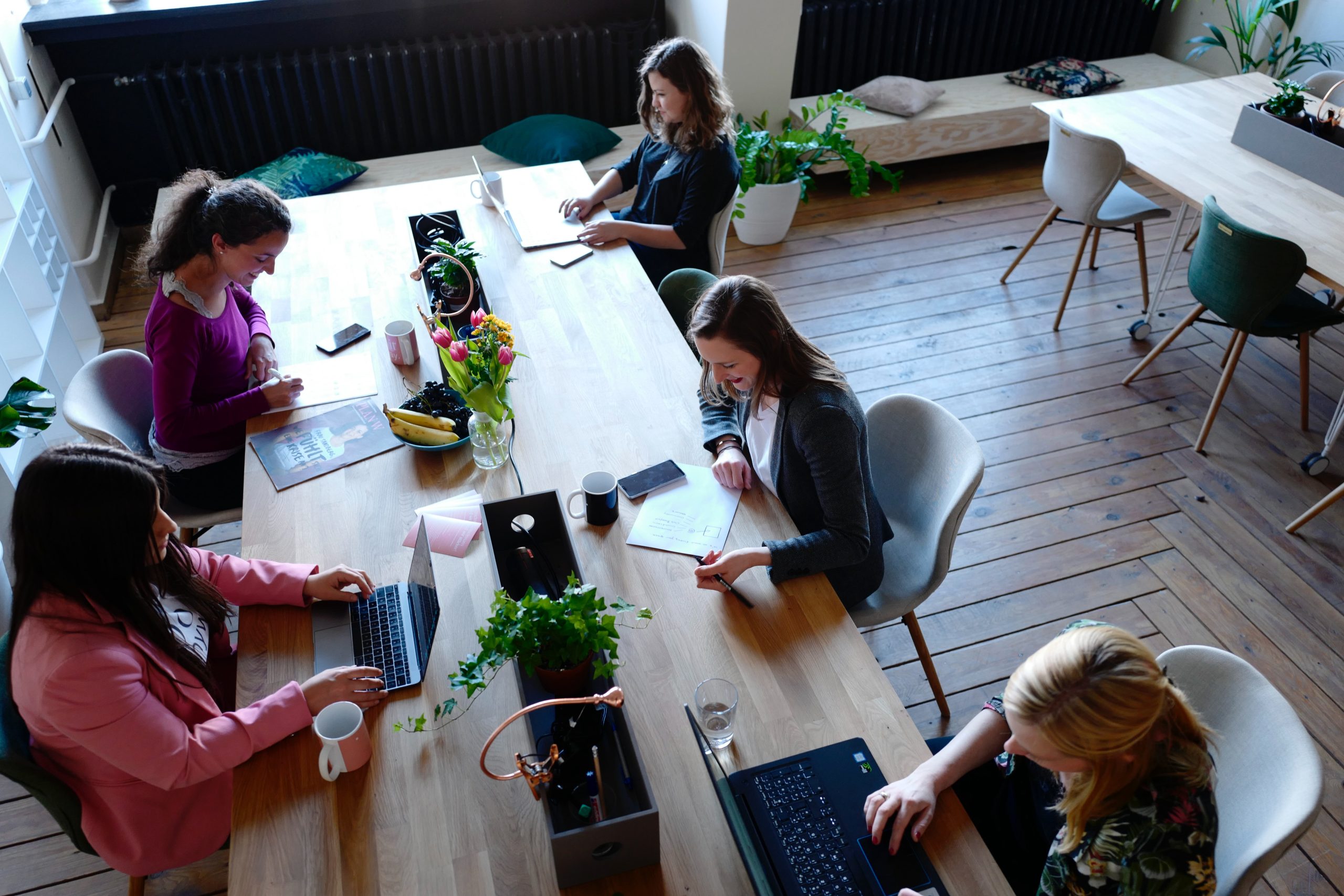 5 women are networking in an open space office